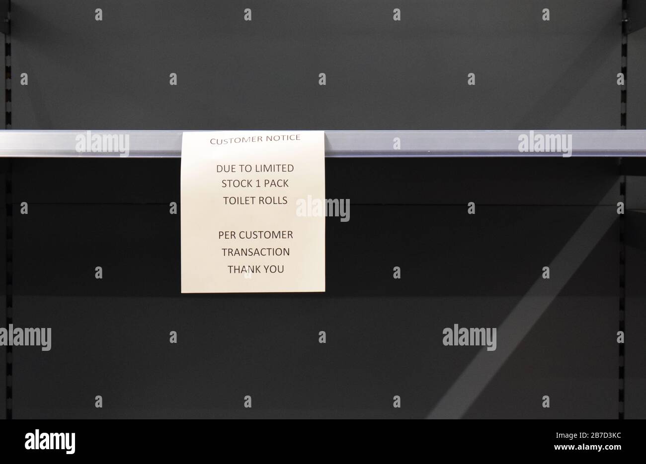 Un seul paquet par client signe sur une étagère de supermarché britannique généralement rempli de rouleau de toilette maintenant vide en raison de l'achat de panique dû à Coronavirus. Banque D'Images