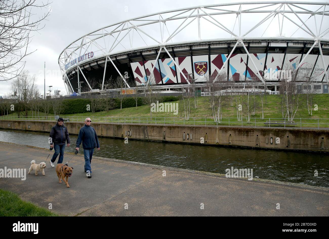 Les gens qui marchent leurs chiens près du London Stadium, stade du West Ham United football Club, après l'annonce de vendredi que la Premier League a suspendu tous les matchs jusqu'au samedi 4 avril 2020. Banque D'Images