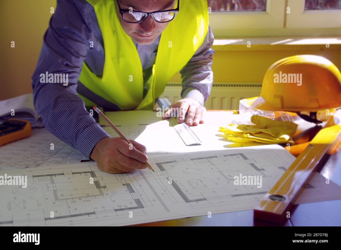 Responsable de la construction, entrepreneur, constructeur ou ingénieur sur le lieu de travail. Homme en train de travailler sur l'esquisse de construction. Architecture, ingénierie et concept industriel. Banque D'Images