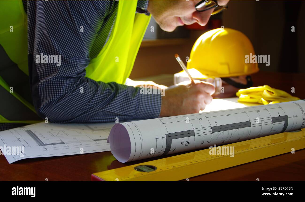 Responsable de la construction, entrepreneur, constructeur ou ingénieur sur le lieu de travail. Homme en train de travailler sur l'esquisse de construction. Architecture, ingénierie et concept industriel. Banque D'Images