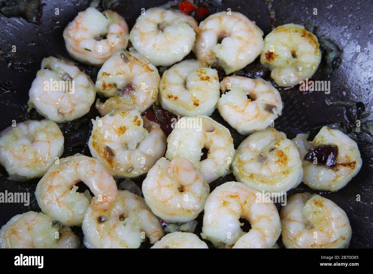 Gros plan de crevettes tigrées épicées fraîches isolées dans une poêle à wok assaisonnée de piment Banque D'Images