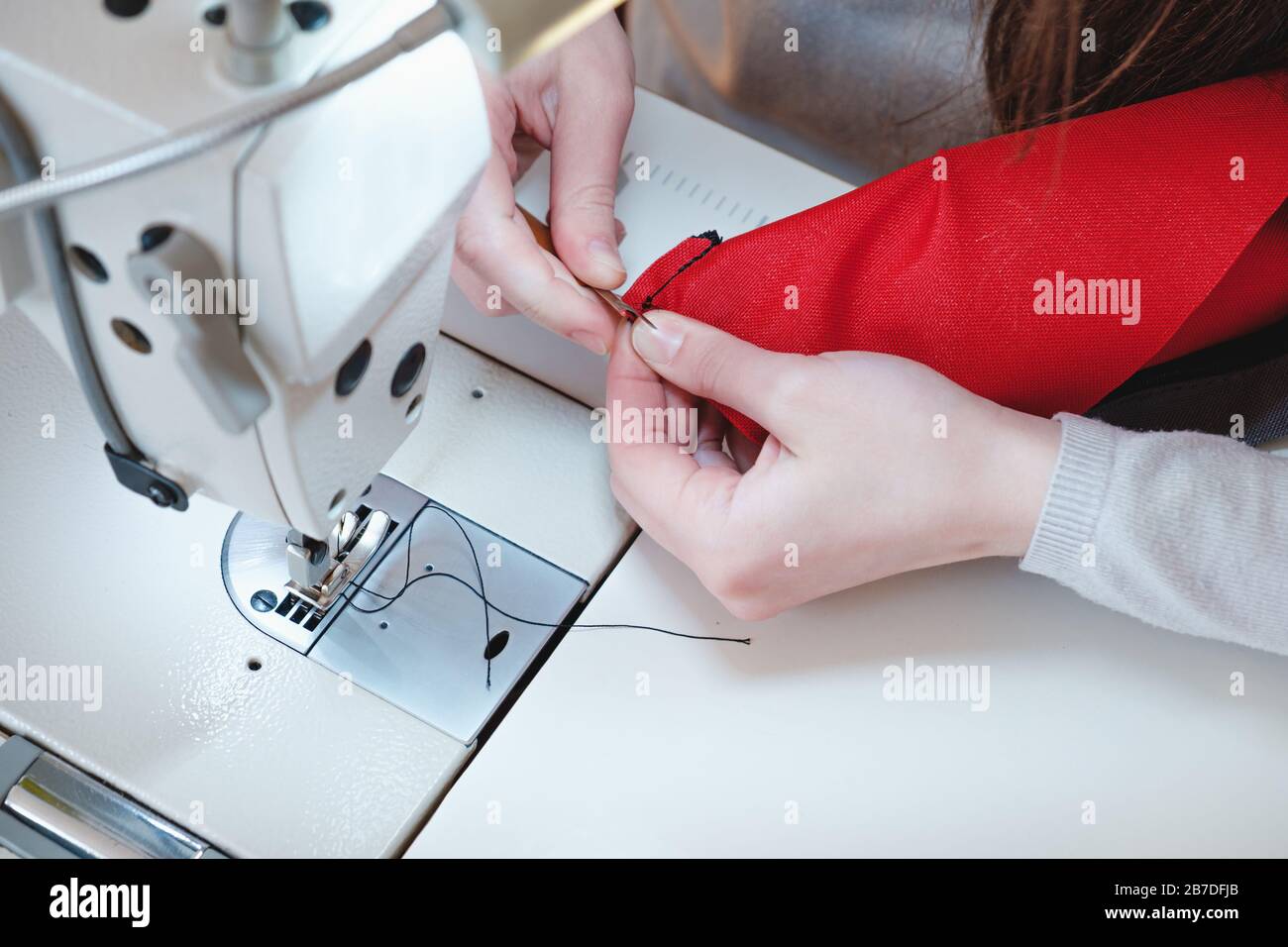 Mains couturières au travail. Needlewoman à la machine à coudre en surverrouillage faisant du travail professionnel, concept de travail Banque D'Images