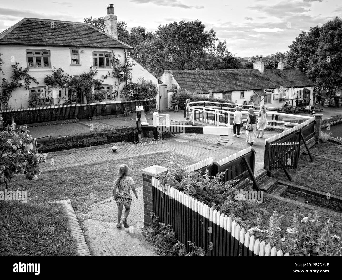 Image en noir et blanc de Foxton écluse et chalet avec enfants marchant près de Foxton sur le Grand Union Canal Leicester Arm, Leicestershire, Angleterre, Royaume-Uni, Banque D'Images