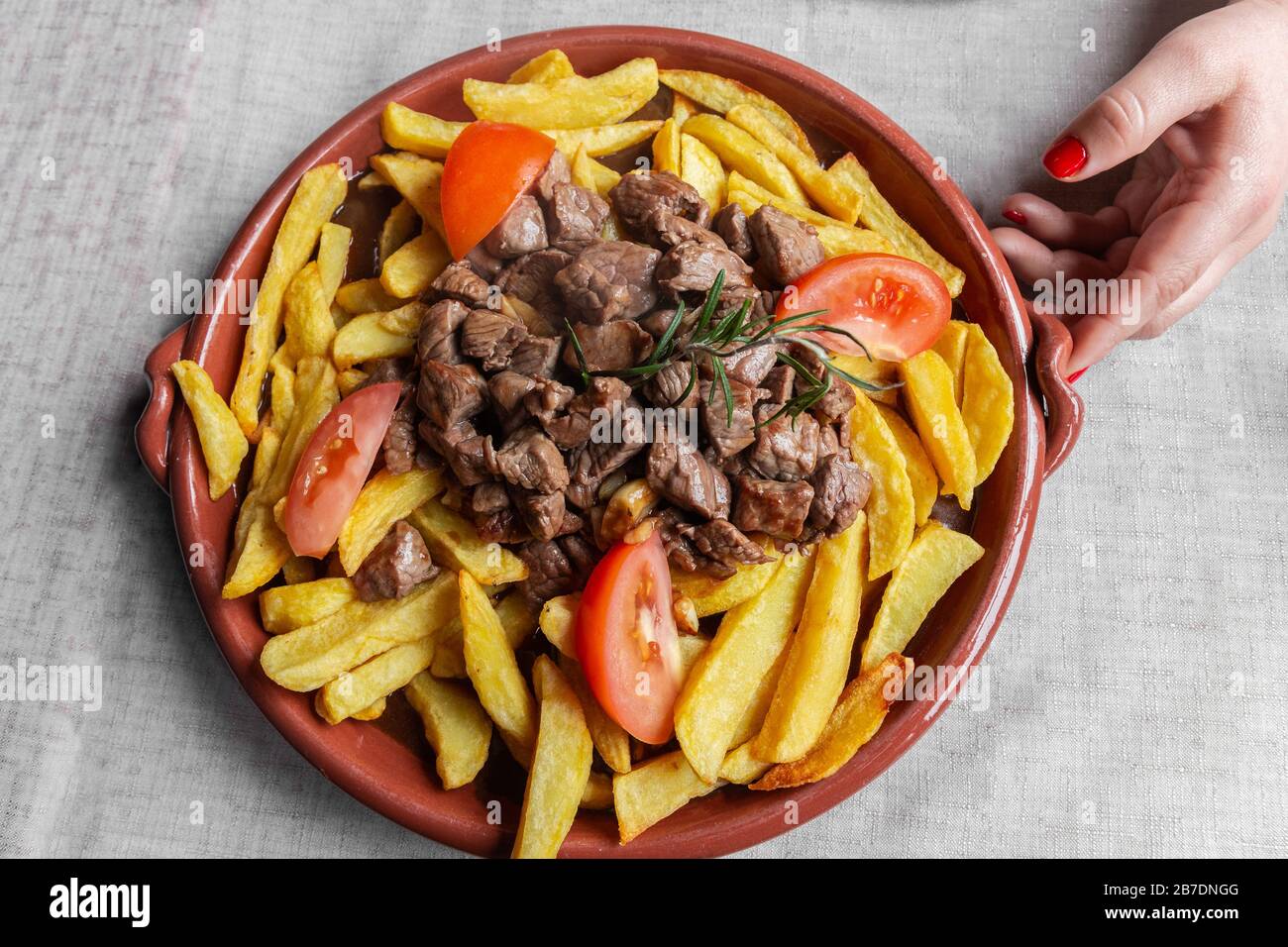 Plat traditionnel de l'île de Madère, appelé 'Picado' ou 'Picadinho', préparé avec du boeuf coupé en petits cubes, frites tranches de tomates et d'ail. Banque D'Images