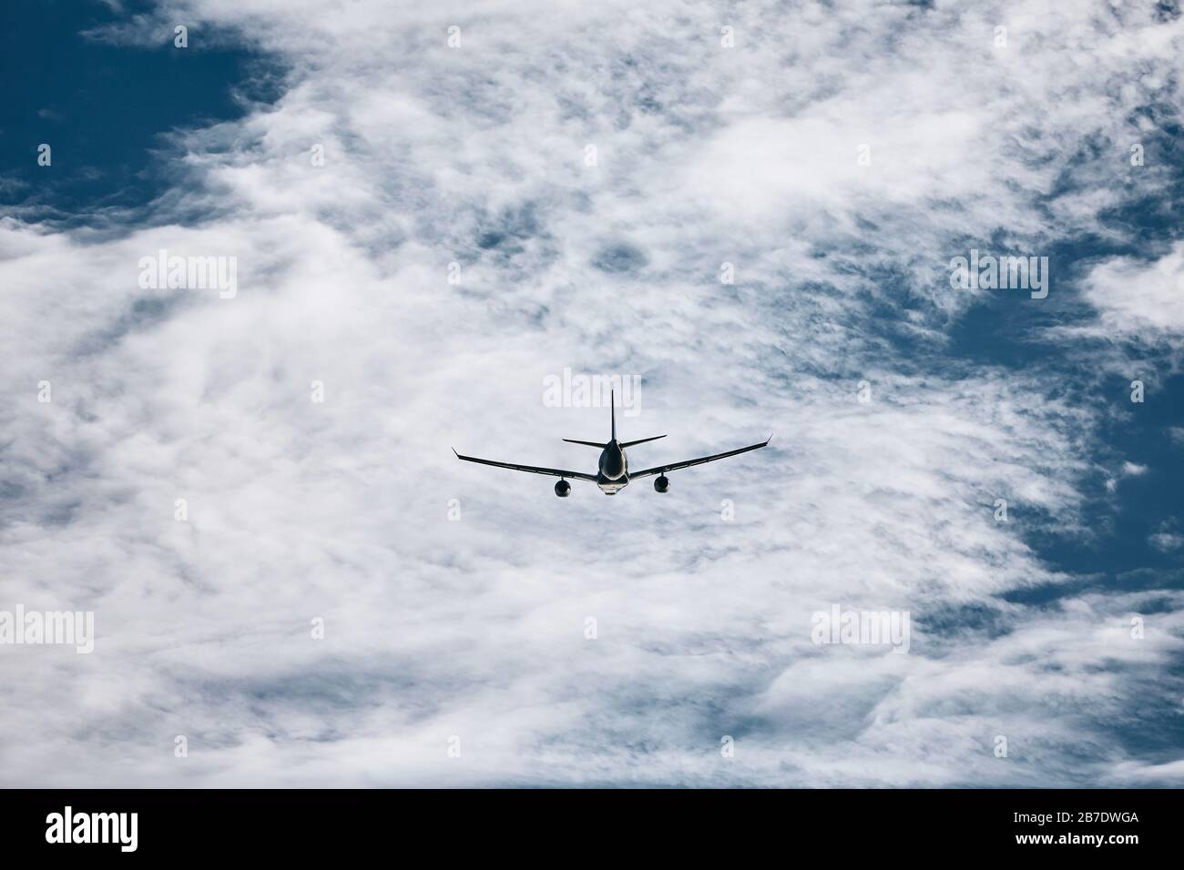Avion commercial volant contre les nuages à la journée ensoleillée. Banque D'Images