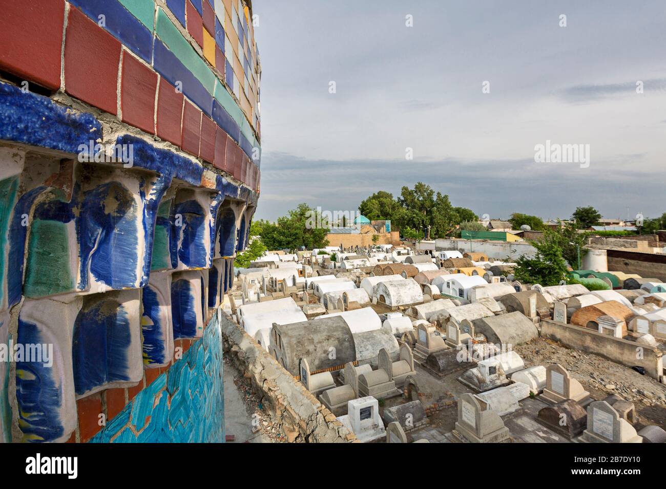 Ancien cimetière au mausolée bleu couté de Madari Khan en arrière-plan, à Kokand, en Ouzbékistan. Banque D'Images