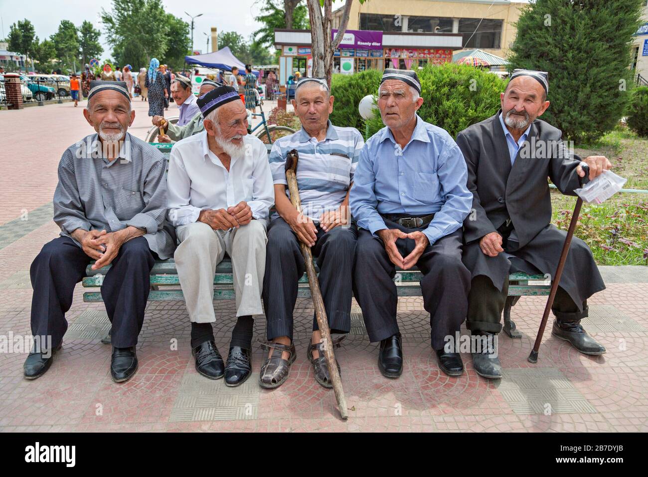 Des hommes locaux ouzbeks âgés assis sur le banc dans un parc, à Margilan, en Ouzbékistan. Banque D'Images