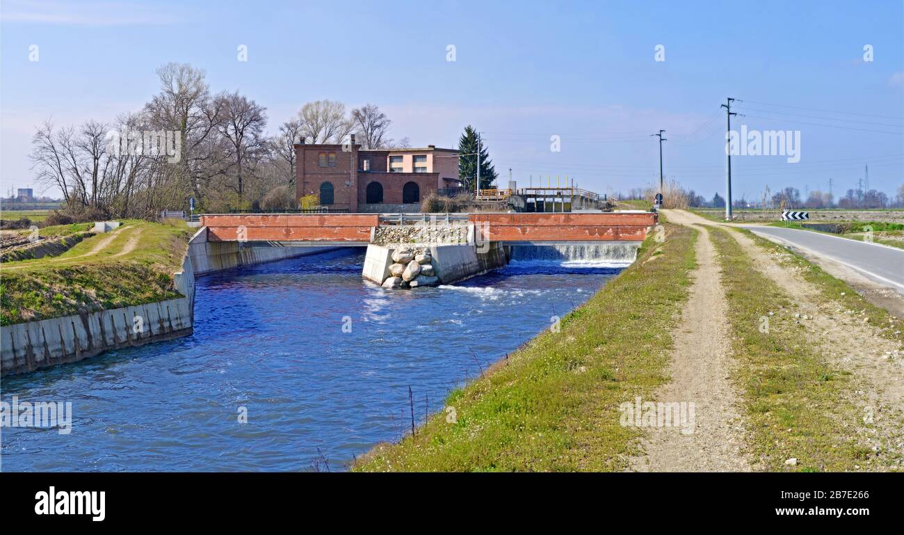 Canale Cavour, traversée par un pont, qui apporte de l'eau à toutes les parcelles environnantes de terre et de champ, PO Valley, Piémont, Italie Banque D'Images