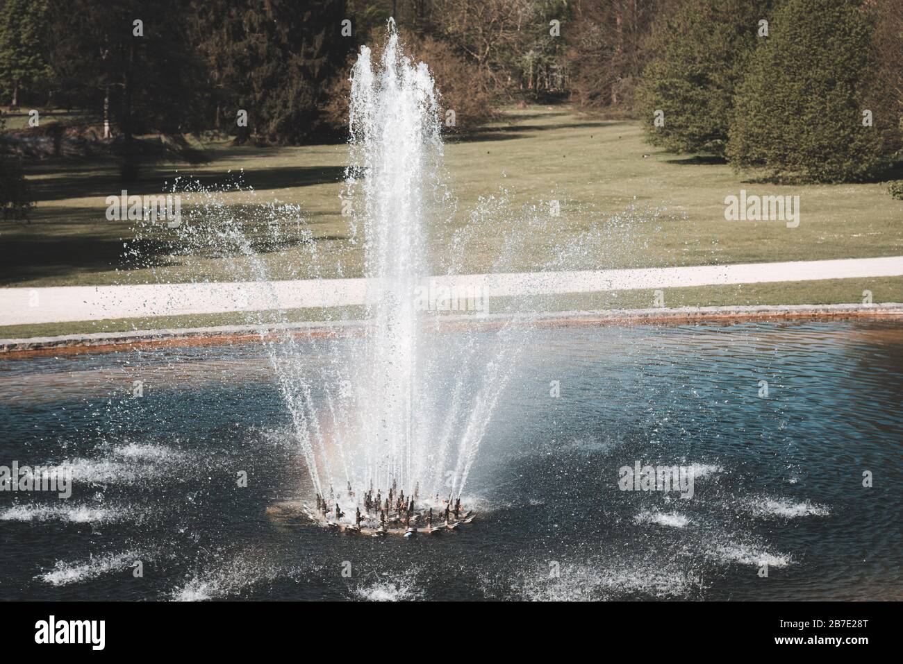 Fontaine d'eau décorative circulaire dans un grand parc Banque D'Images
