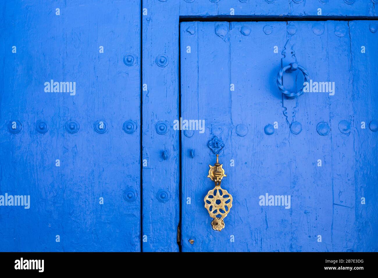 Arrière-plan de la porte traditionnelle peinte en poudre bleu avec porte de golde. Chefchaouen, Maroc Banque D'Images