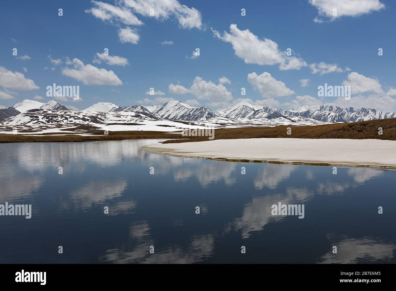 Lac de montagne au sommet des montagnes de Barskaun, avec des réflexions dans l'eau au Kirghizstan Banque D'Images