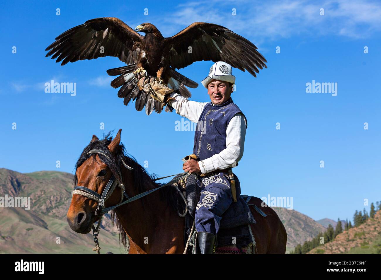 L'entraîneur d'aigle doré tient son aigle Issyk Kul Lake, Kirghizstan Banque D'Images