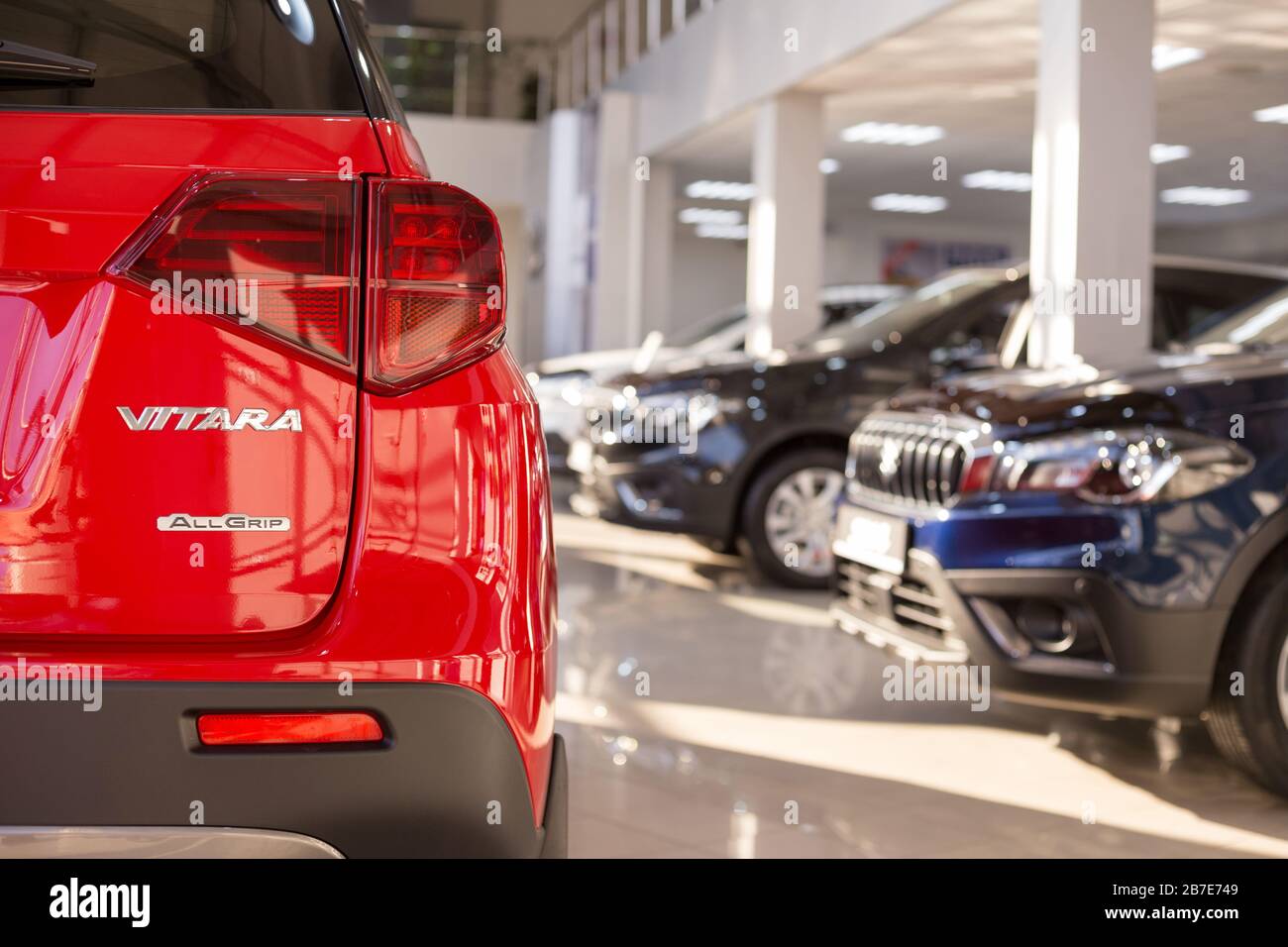Russie, Izhevsk - 05 mars 2020: Nouvelles voitures modernes dans la salle d'exposition Suzuki. Célèbre marque mondiale. Fond flou à thème avec effet bokeh. Banque D'Images