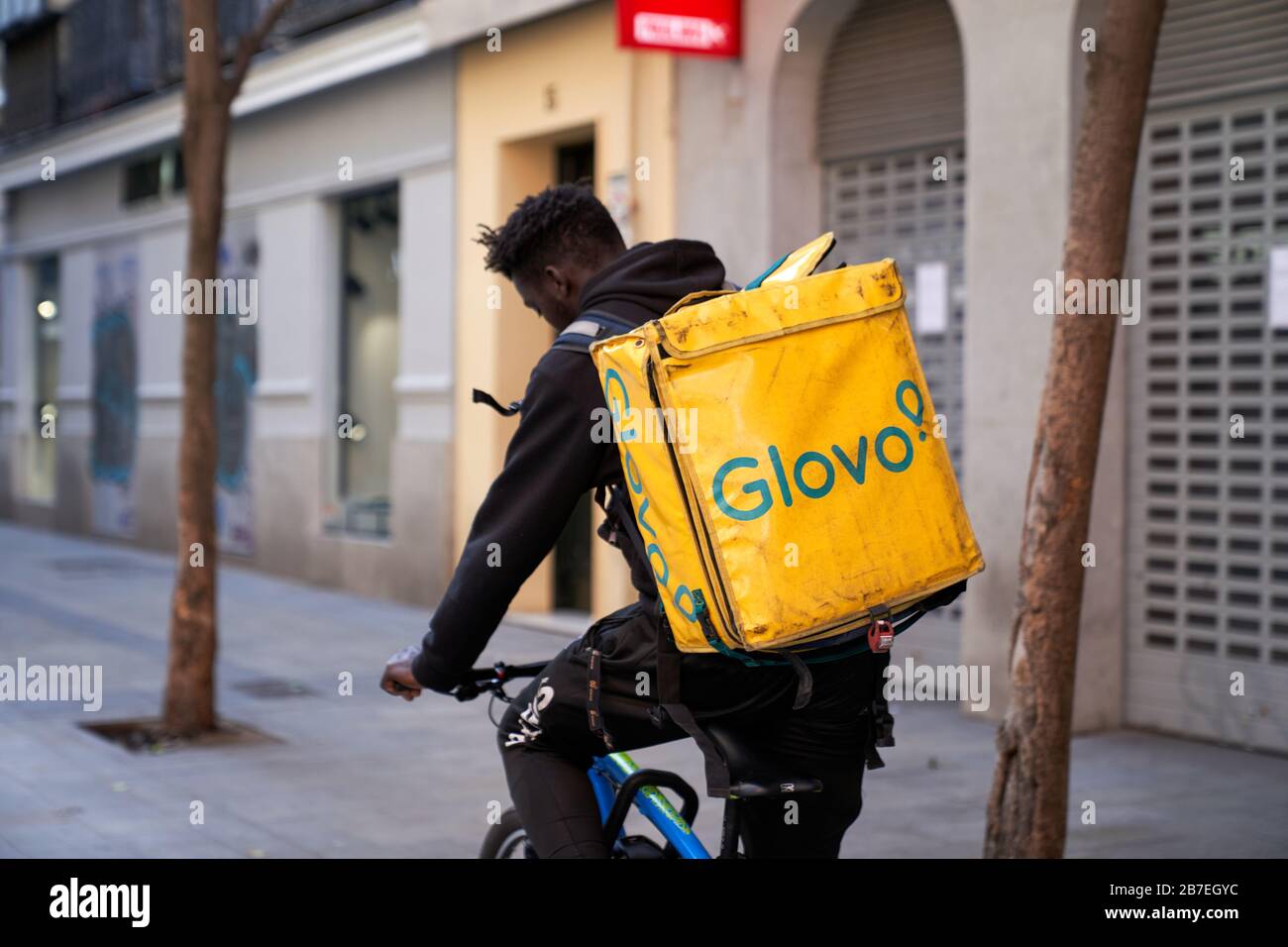 Un motard de livraison Glovo descend normalement occupé Calle Fuencarral, il est principalement des marcheurs de chien et des gens de livraison hors pendant l'état d'urgence Banque D'Images