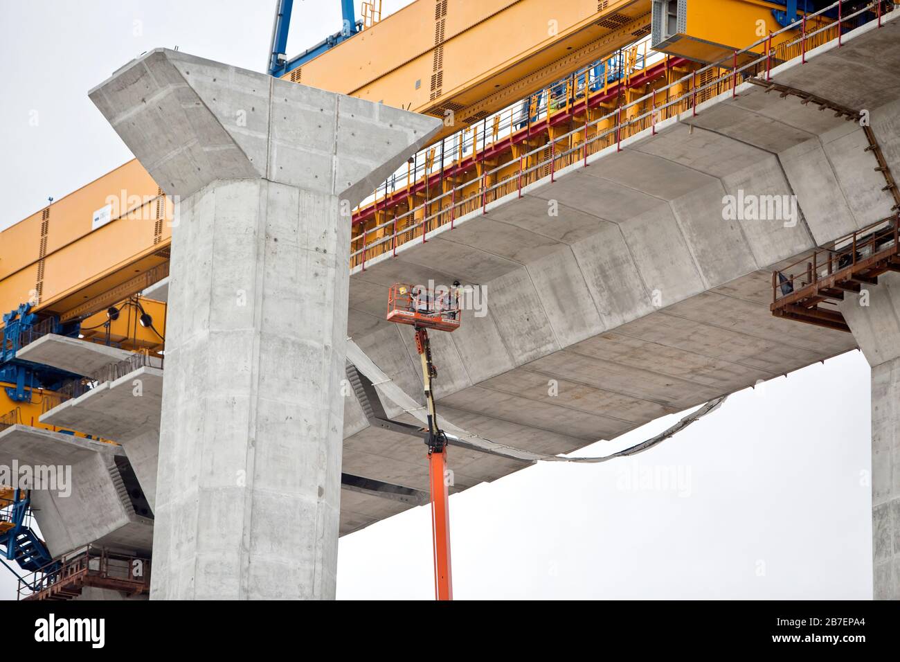 Construction du nouveau Harbour Bridge, le travailleur a suspendu avec un relevage hydraulique étendu, nettoyant les joints en ciment sous le pont. Banque D'Images