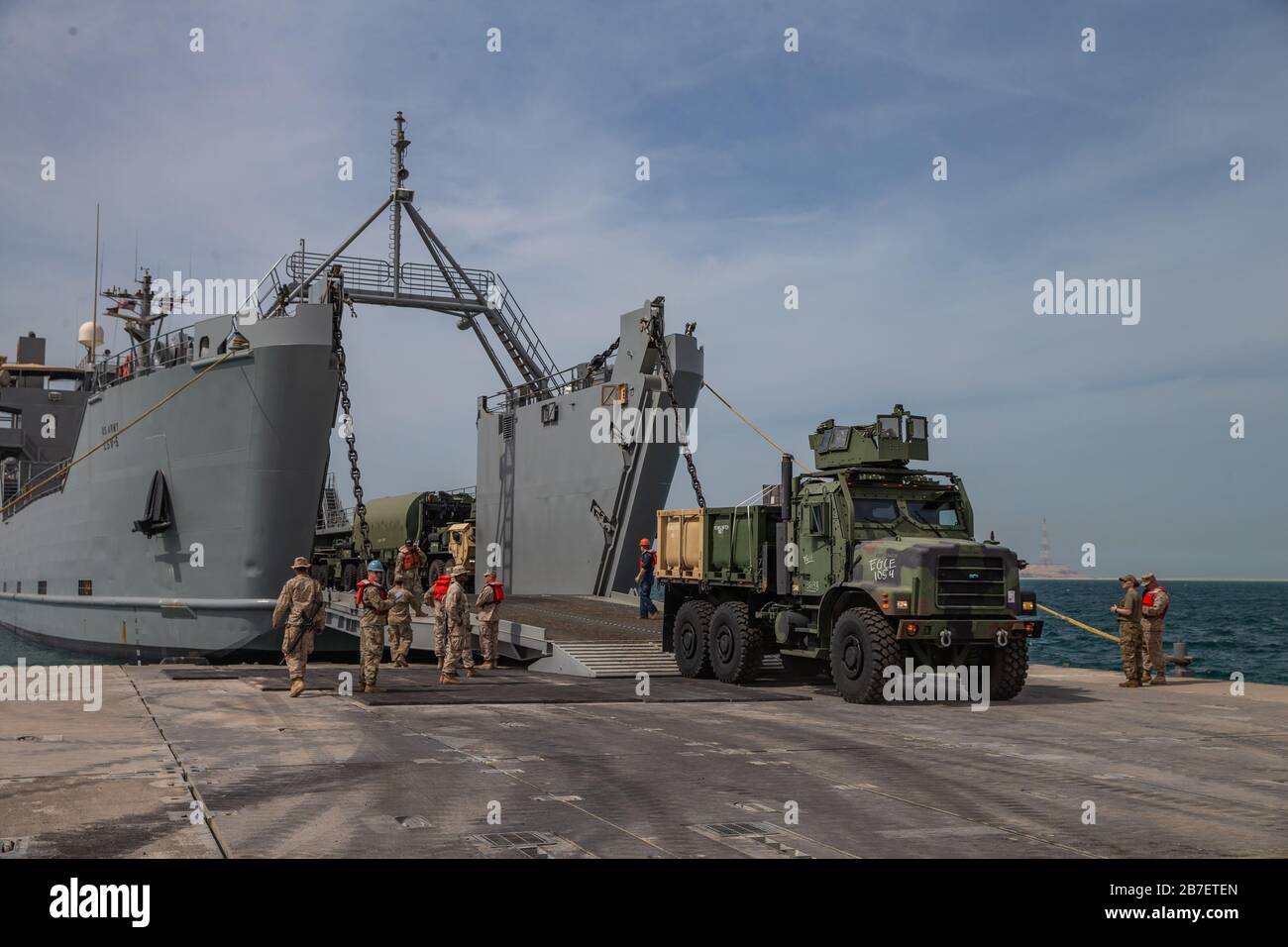 Les Soldats américains du 11ème Bataillon des transports, 7ème brigade des transports expéditionnaire, travaillent aux côtés des marines américaines avec I Marine Expeditionary Force pour décharger un navire de soutien logistique pendant l'exercice Native Fury 20 aux Émirats arabes Unis, le 13 mars 2020. La Fury indigène est conçue pour accroître les capacités des forces armées américaines à planifier, communiquer et mener des opérations complexes en mer et en terre en réponse aux catastrophes naturelles et à d'autres éventualités. (ÉTATS-UNIS Photo du corps marin par lance Cpl. Brendan Mullin) Banque D'Images