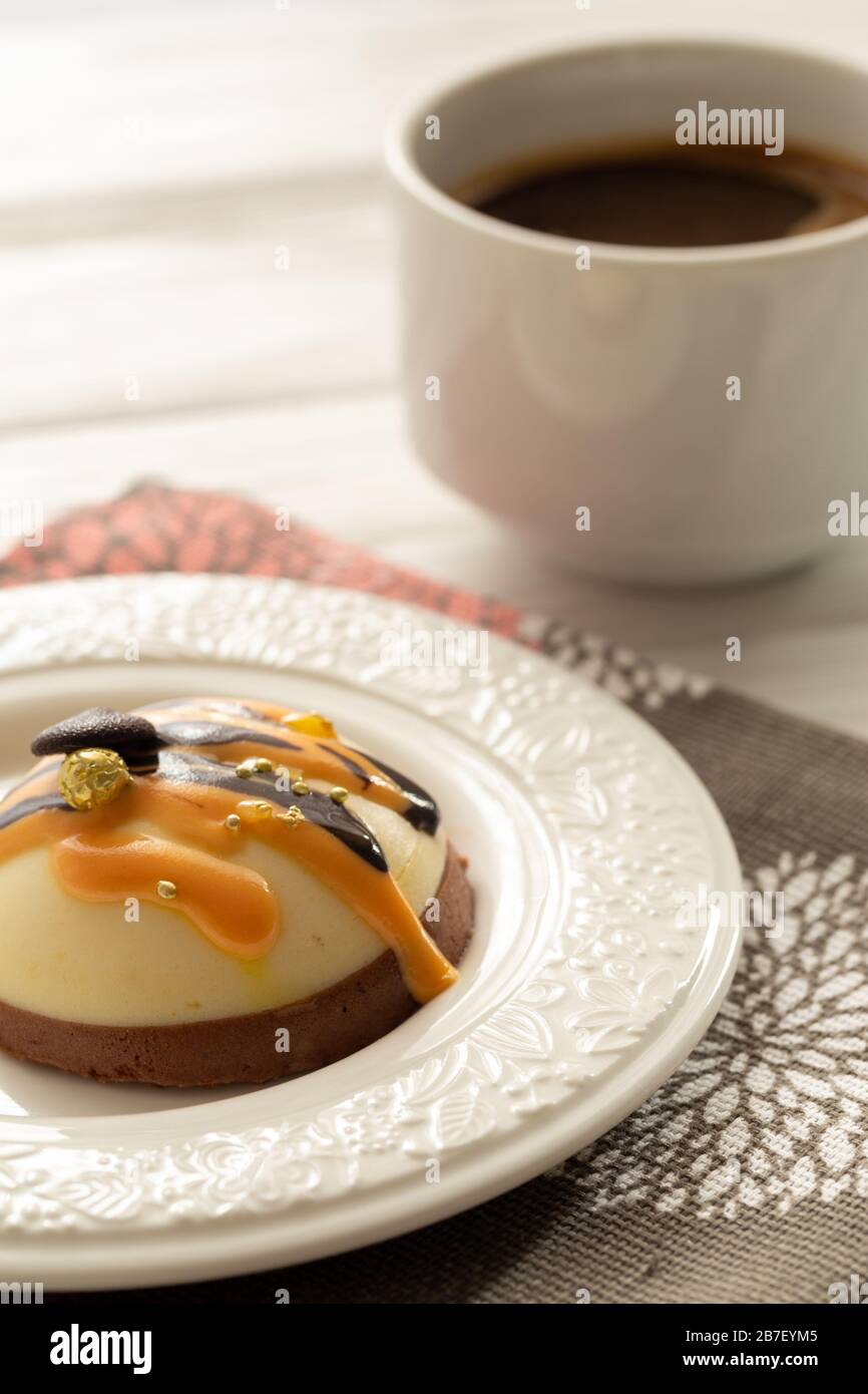 Toujours la vie avec une tasse de café et un gâteau sucré sur la table en bois blanc. Petit-déjeuner le matin au soleil Banque D'Images Toujours la vie avec une tasse de café et un gâteau sucré sur la table en bois blanc. Petit-déjeuner le matin au soleil Banque D'Images