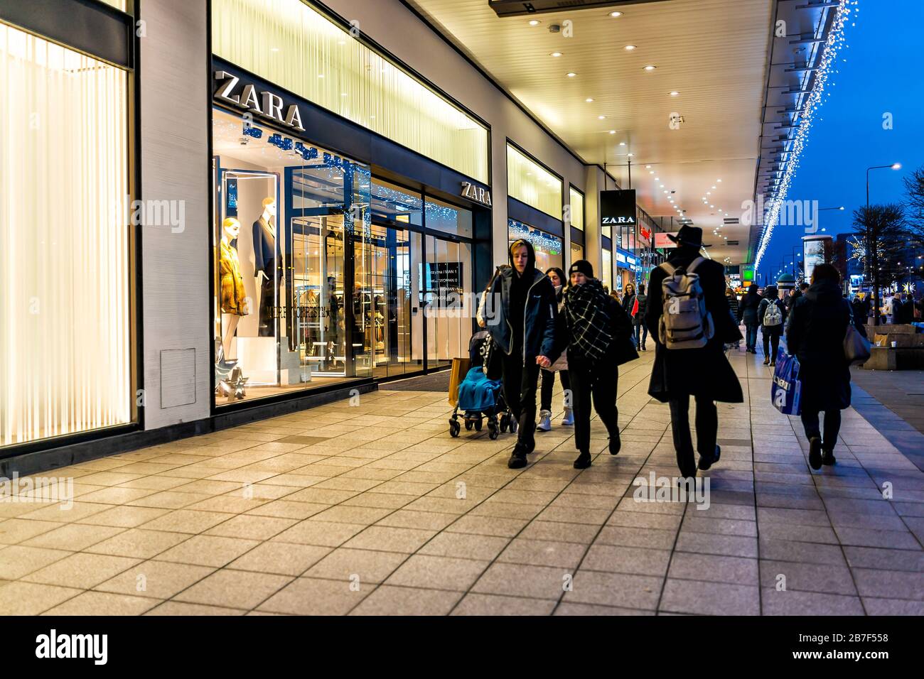Varsovie, Pologne - 19 décembre 2019: Espagnol Zara rapide magasin de mode  signe entrée avec les gens marchant sur le trottoir de la rue Marszalkowska  la nuit avec C Photo Stock - Alamy