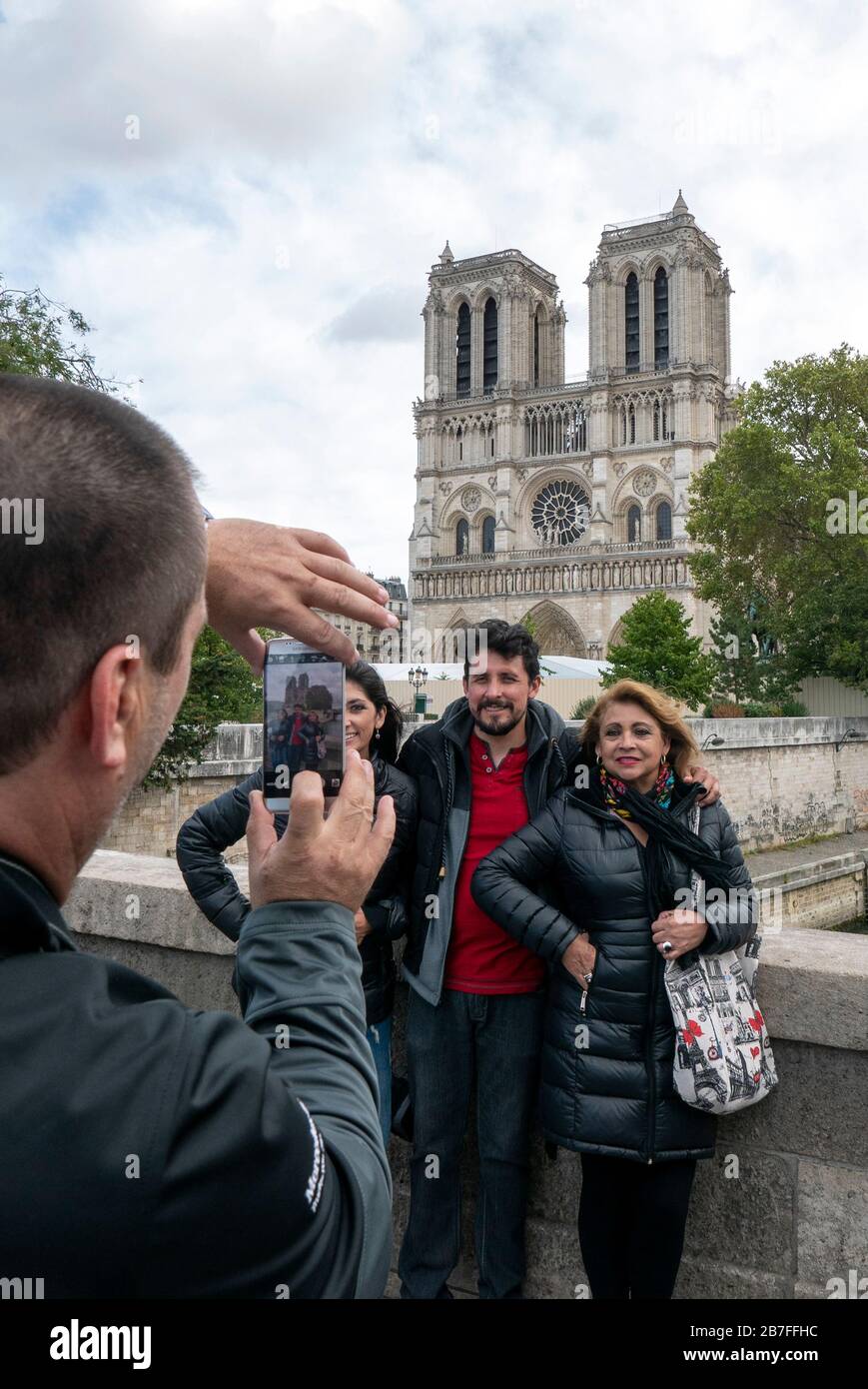 Touristes se posant pour une photo devant la cathédrale notre Dame de Paris, France, Europe Banque D'Images