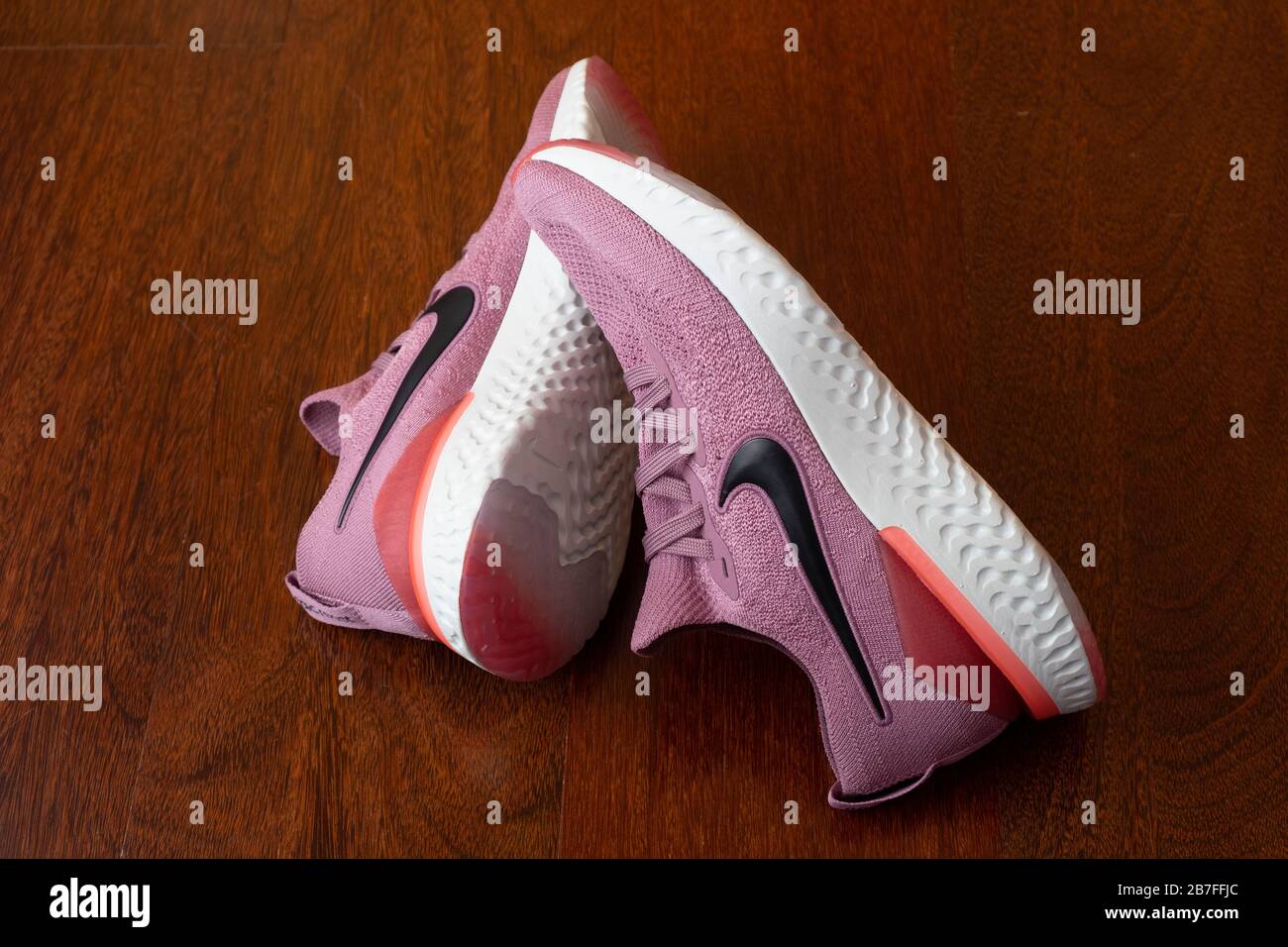 Paire de chaussures de course à pied roses Nike Epic React 2 sur parquet Banque D'Images