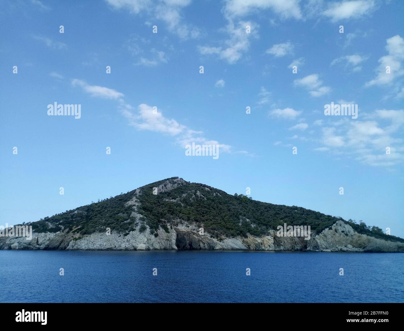 Île de Kelyfos entre Sithonia et Kassandra près de Neos Marmaras avec ciel bleu rempli de petits nuages. Banque D'Images