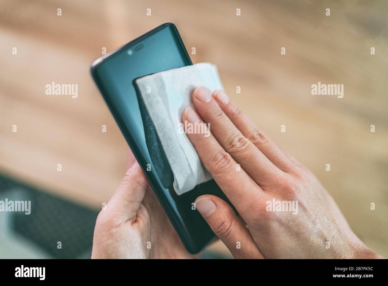 Nettoyage de l'écran du téléphone portable avec lingettes désinfectantes humides pour un nettoyage préventif du smartphone pour la prévention de la contamination par l'éclosion de COVID-19 Coronavirus. Banque D'Images