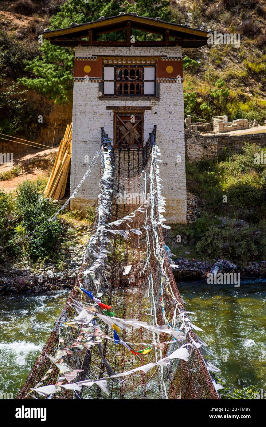 Pont suspendu de la chaîne de fer Tachog Lhakhang du XVe siècle traversant la rivière Paro Chu au Bhoutan par une journée ensoleillée Banque D'Images