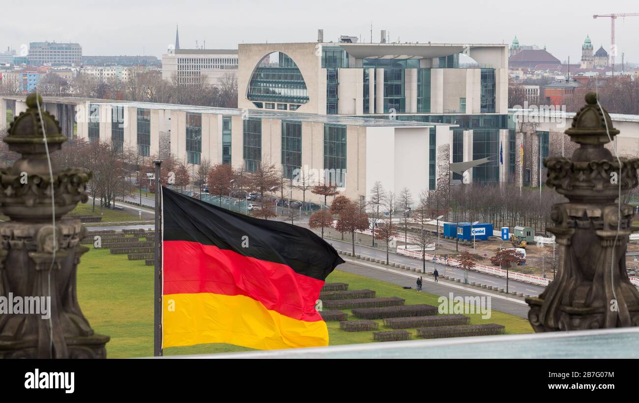 Vue sur la résidence du Chancelier allemand avec un drapeau allemand agitant au premier plan. Banque D'Images
