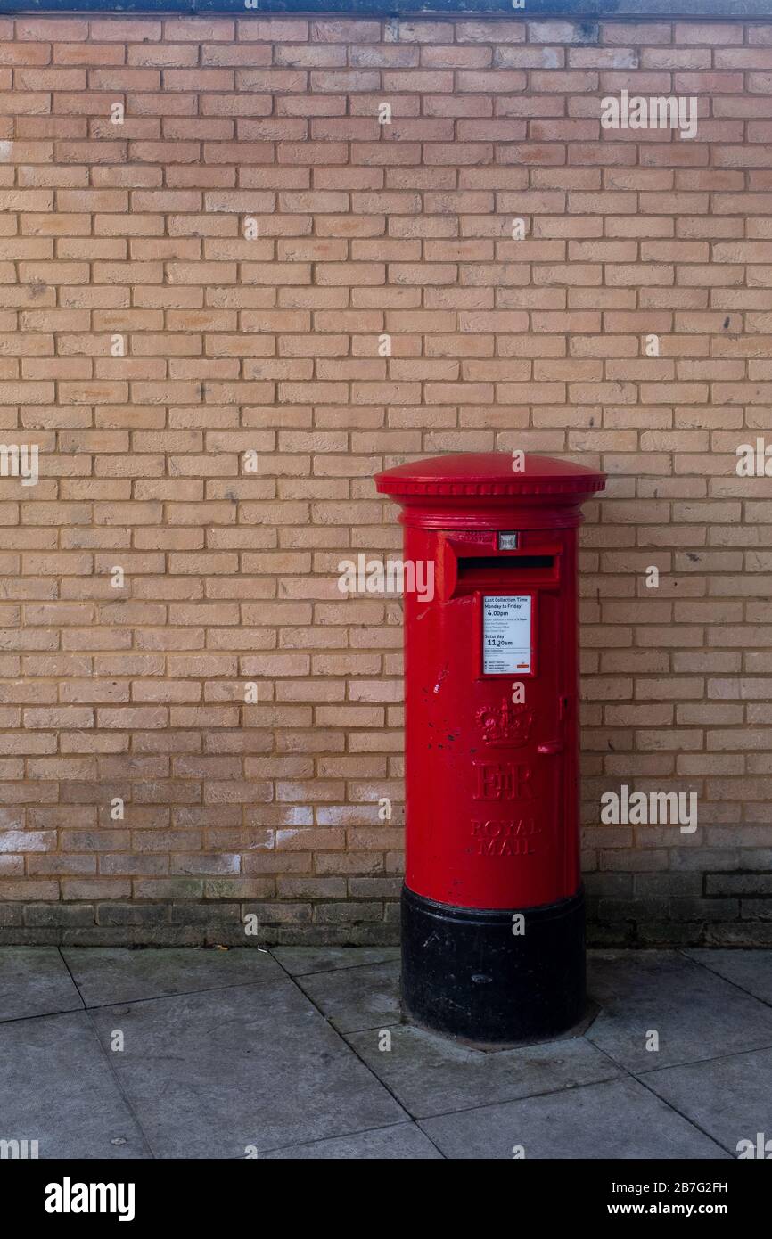 Seul un rouge Royal Mail lettre fort contre un mur en brique de couleur orange. Beaucoup d'espace pour copier l'espace et pas de personnes dans l'image Banque D'Images