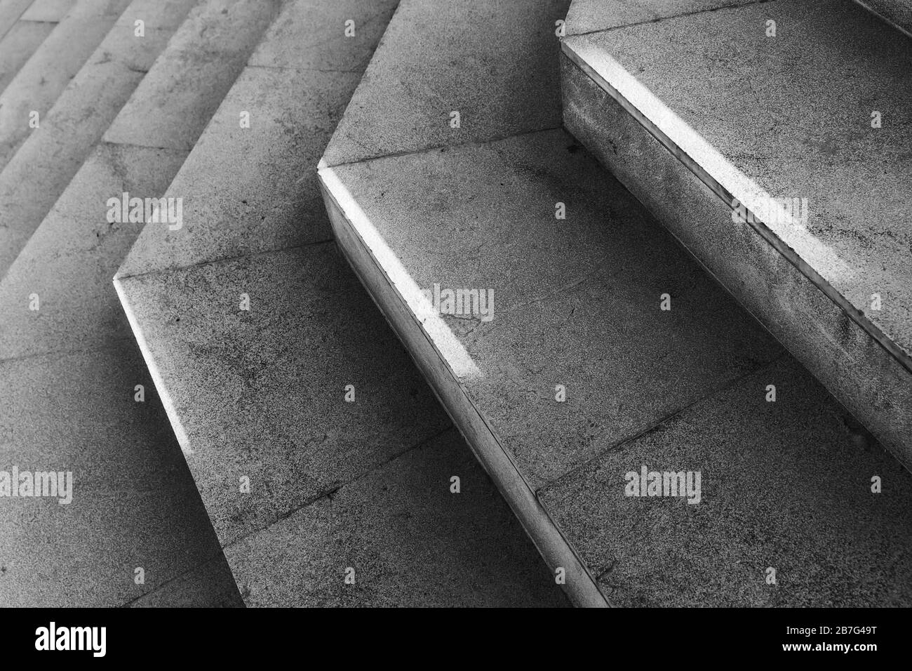 Escaliers en pierre gris foncé vides avec lumière du soleil vive dessus. Photo d'arrière-plan noire et blanche abstraite Banque D'Images