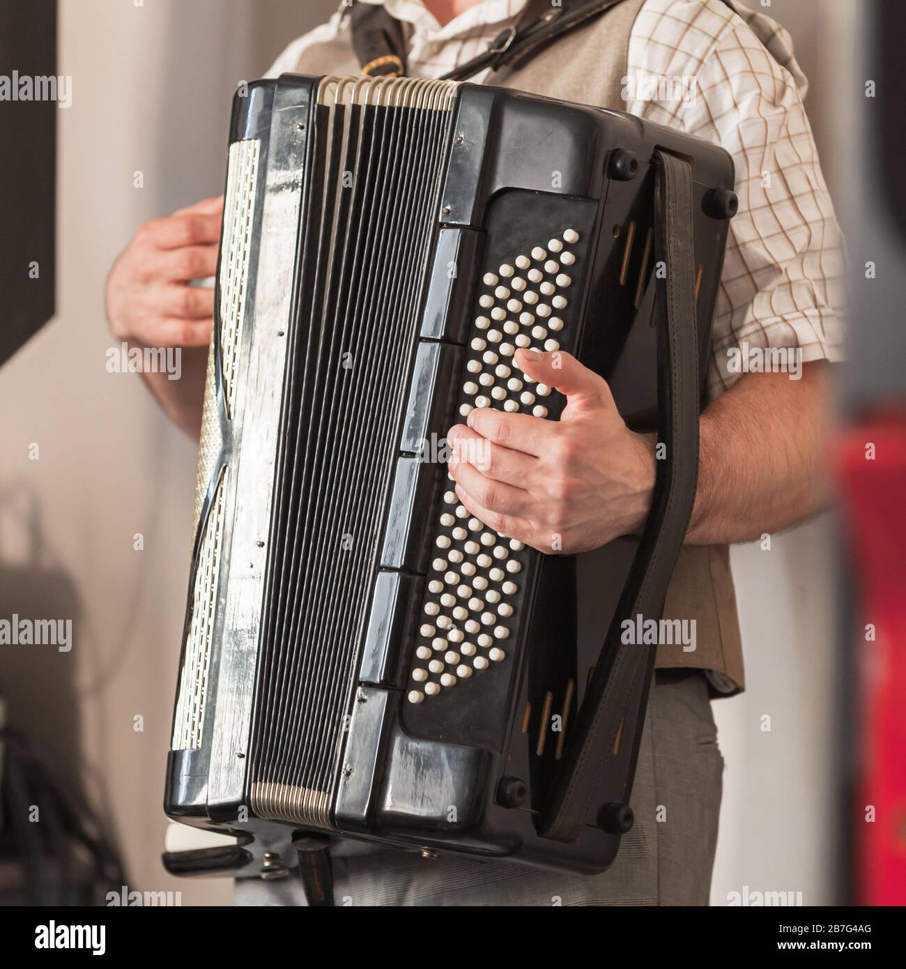 Fond musical en direct. L'accordéoniste joue de l'accordéon noir vintage. Gros plan photo carrée Banque D'Images