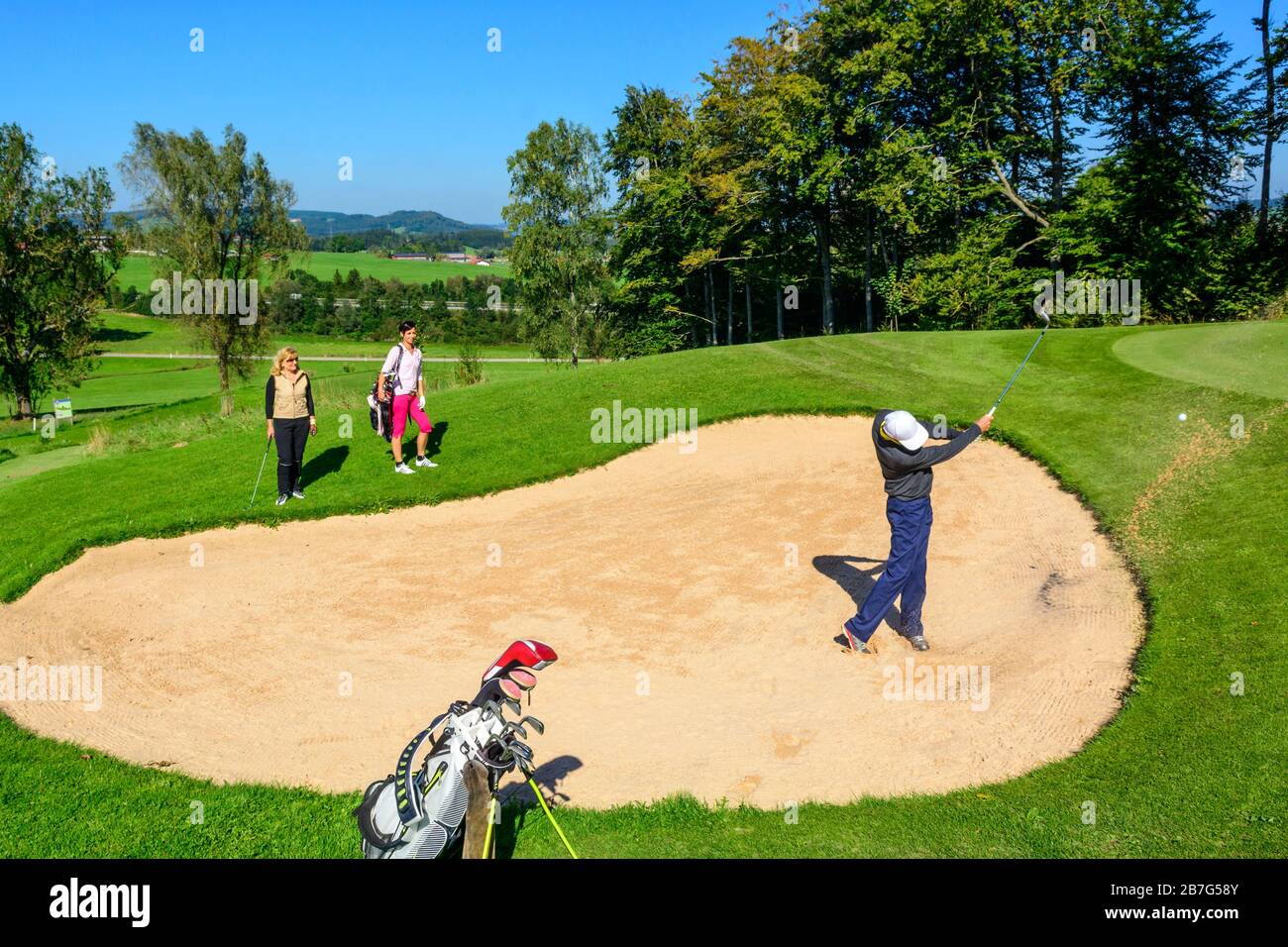 Joueur de golf frapper la balle d'un bunker Banque D'Images