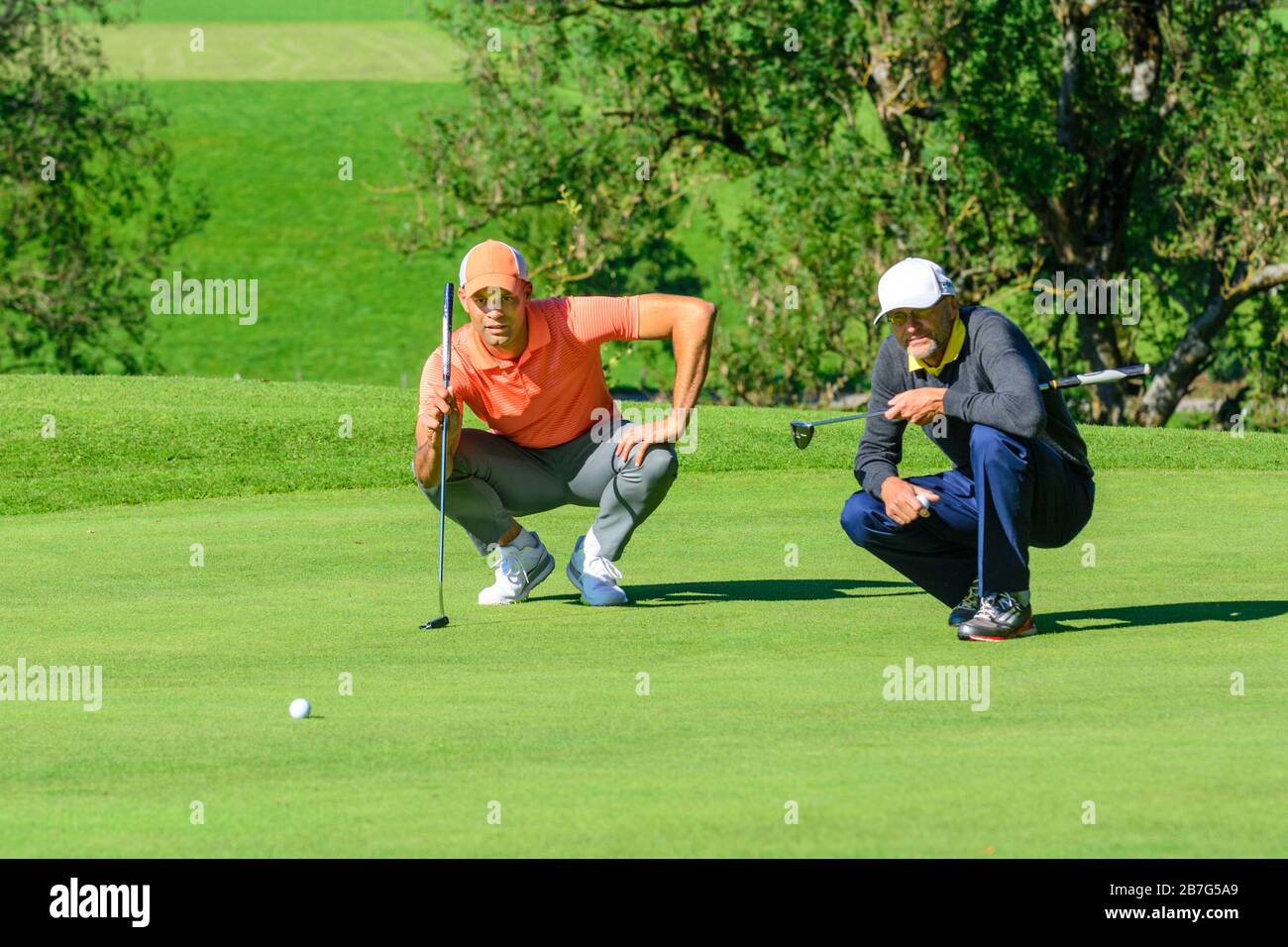 Deux golfeurs de golf sur vert à une journée ensoleillée dans l'allgäu bavarois près de Kempten Banque D'Images