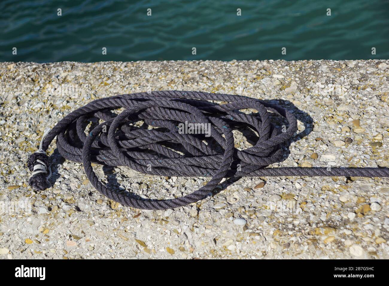 Une corde de voile blanche sur un quai Banque D'Images