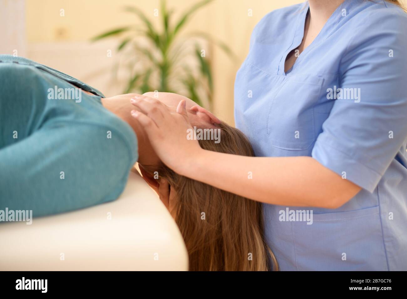 Un physiothérapeute ou un chiropraticien femelle patients réglage du cou. La physiothérapie, réadaptation concept. Vue latérale cropped shot. Banque D'Images
