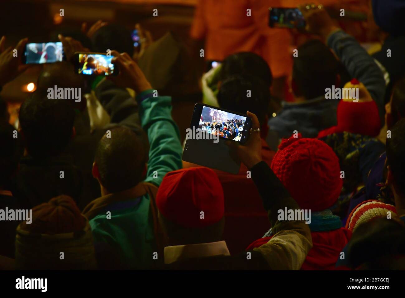 Des centaines de personnes se réunissent lors de la cérémonie Aarti en soirée. Les gens filmant la cérémonie avec des smartphones. Varanasi, Inde Banque D'Images