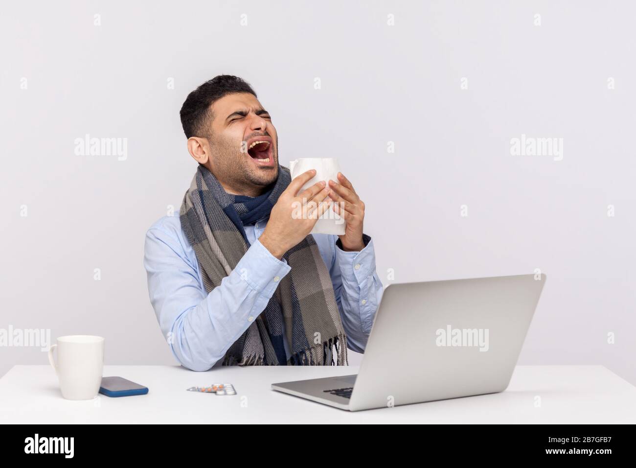 Homme d'affaires malade de la grippe éternuant dans les tissus, assis au bureau se sentant mal, risque d'infection de coronavirus, maladie contagieuse 2019-nCoV, epid de l'influenza Banque D'Images