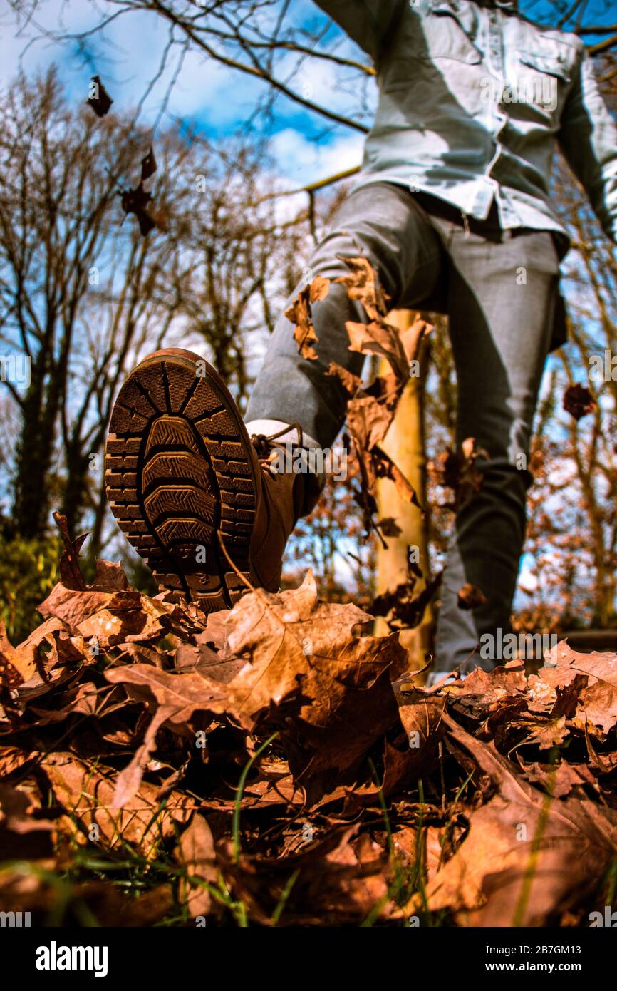 Un homme qui se kicking part dans l'air, ciel bleu, automne Banque D'Images