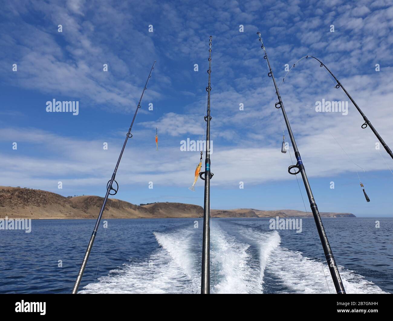 Des rods de pêche à l'arrière du bateau sur l'océan avec un ciel bleu Banque D'Images