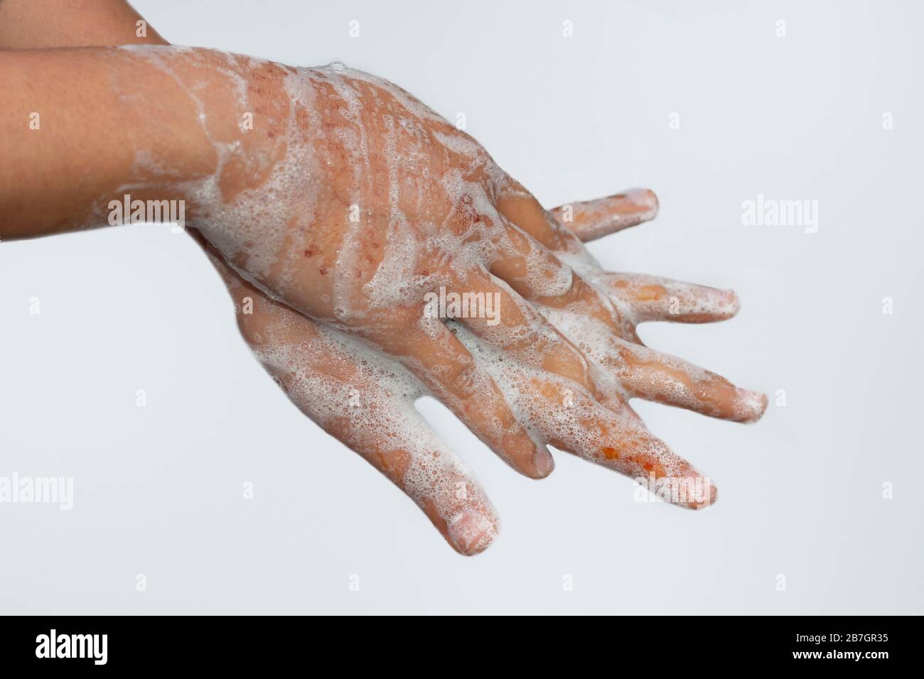 Une fille asiatique se laver les mains avec du savon isolé avec fond blanc. Concept d'hygiène.pour éviter le virus corona (covid-19). Mise au point sélective. Banque D'Images
