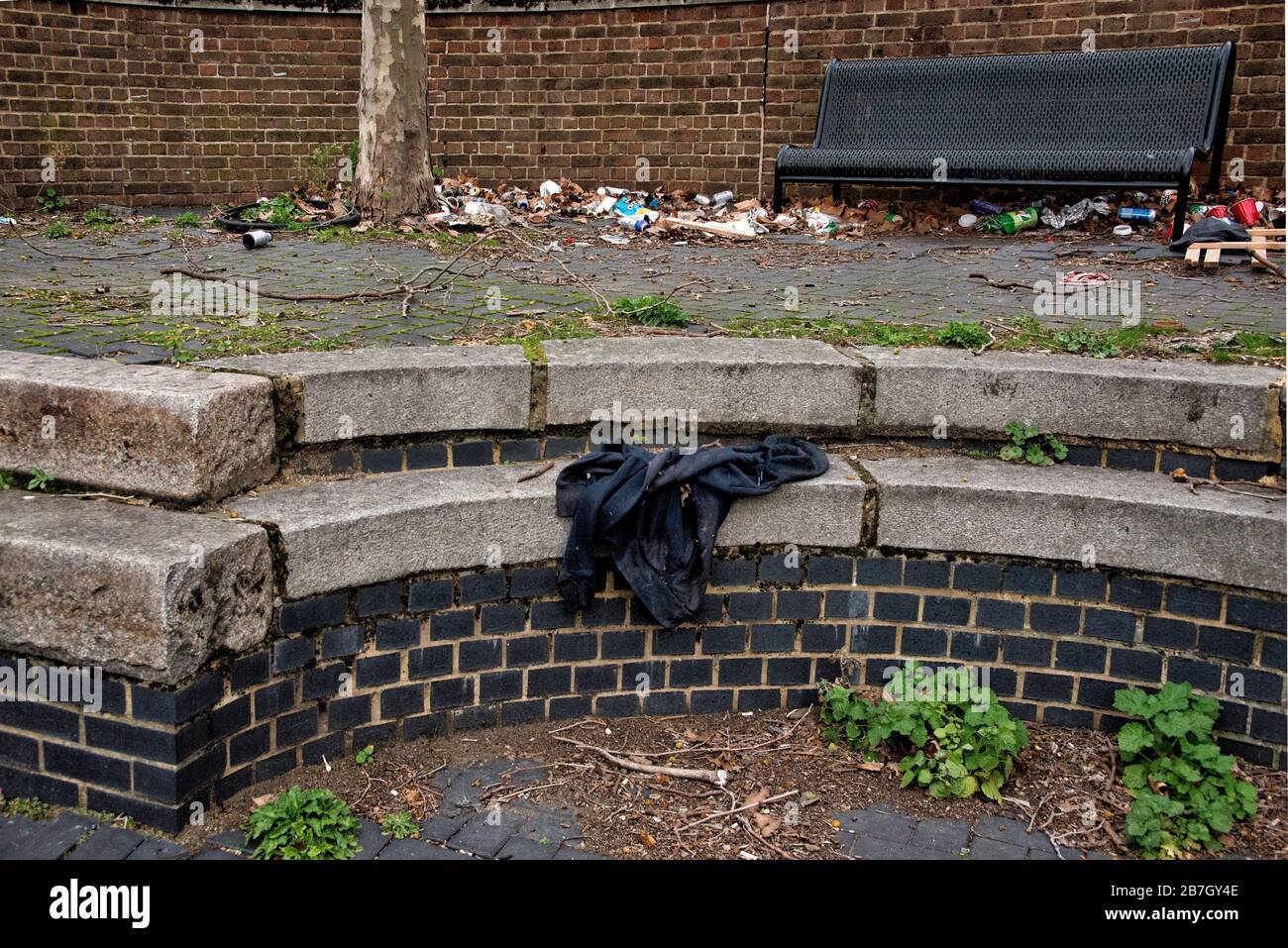 Des ordures sont rayées sous un siège sur la rue côté Londres. Banque D'Images