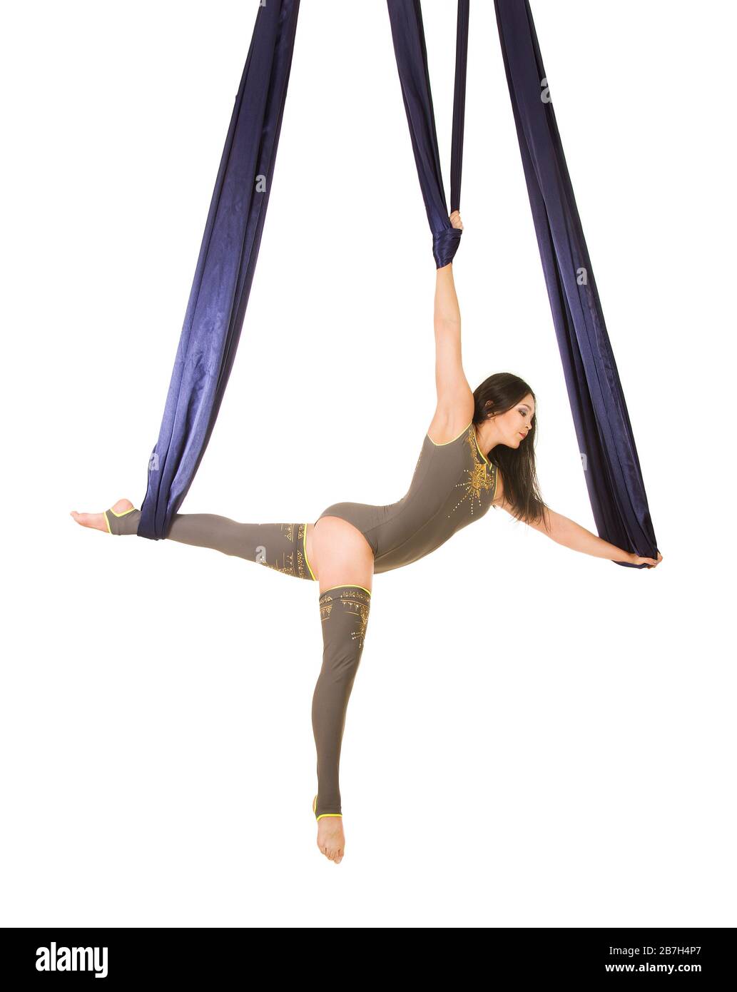 Jeune, souriant acrobat, avec de longs cheveux, dans un costume gris et des leggings faisant des exercices sur la soie bleu aérée . Prise de vue studio sur fond blanc. Banque D'Images