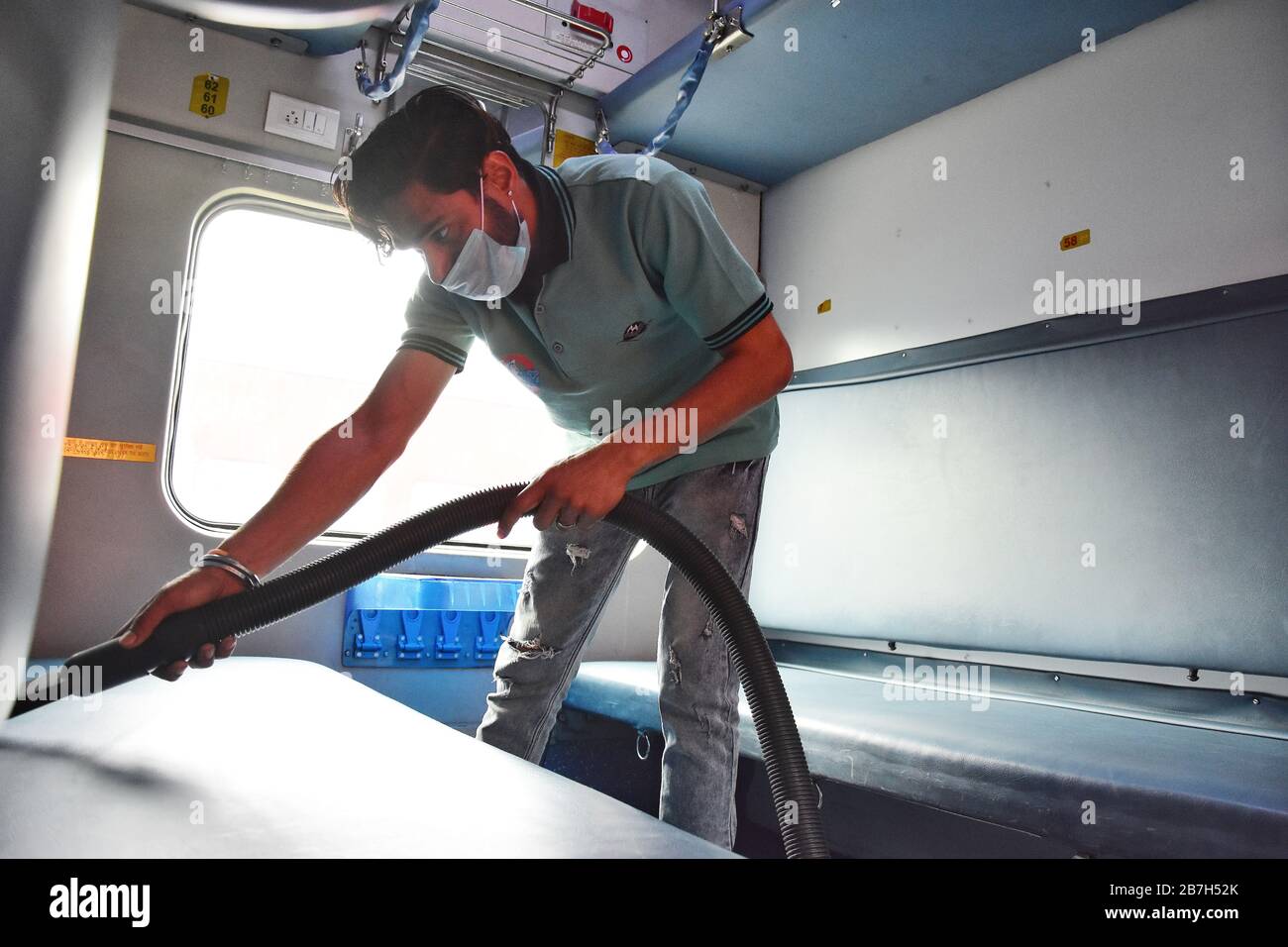 Delhi, Inde. 16 mars 2020. Un travailleur désinfecte l'intérieur d'un train de voyageurs stationné à la gare de New Delhi comme mesure préventive contre le coronavirus. Au total, 114 cas ont été confirmés en Inde, avec 13 personnes soignées et deux morts. Crédit: SOPA Images Limited/Alay Live News Banque D'Images