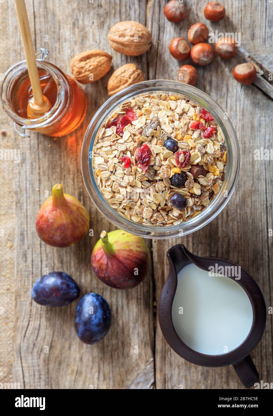 Plat petit déjeuner sain. Un bol avec flocons d'avoine, fruits et noix sur fond en bois. Portrait vertical de la nourriture pour un style de vie sain. Banque D'Images