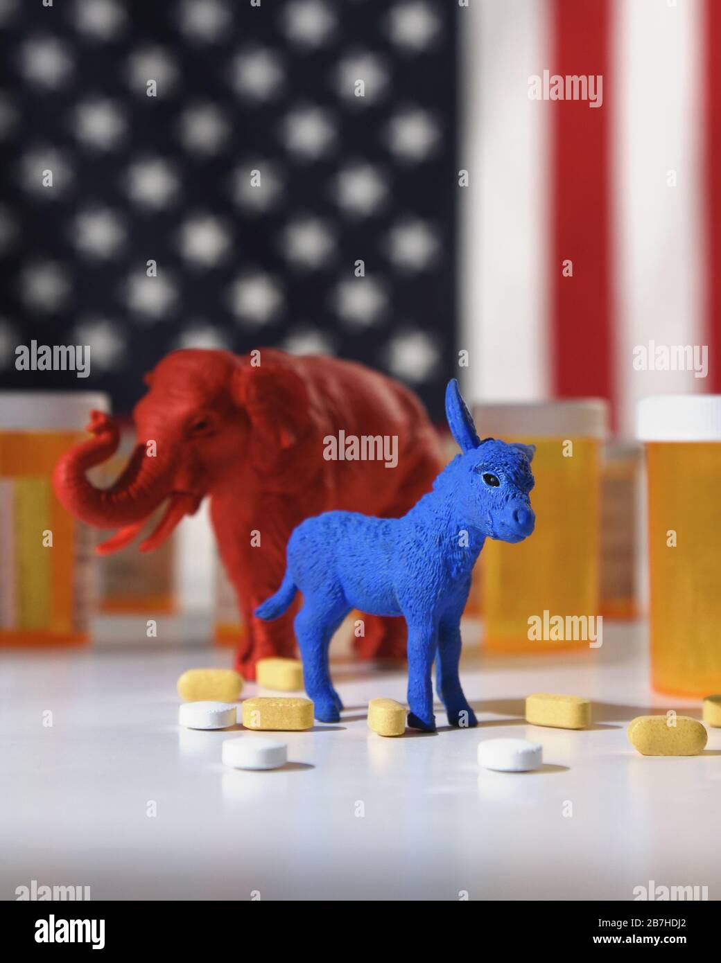 Un âne bleu en tant que démocrate et un éléphant rouge en tant que retublica sont contre un drapeau américain avec des bouteilles de pilule d'ordonnance pour un concept de coût médical Banque D'Images