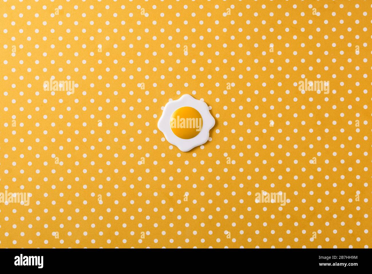 Oeuf frit minimaliste sur fond jaune Banque D'Images