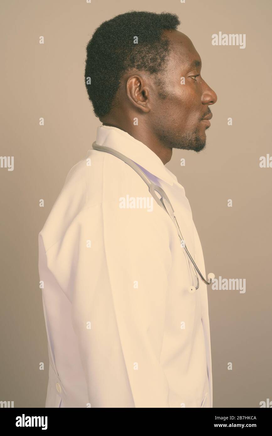 Portrait de jeune homme africain beau médecin contre l'arrière-plan gris Banque D'Images Portrait de jeune homme africain beau médecin contre l'arrière-plan gris Banque D'Images