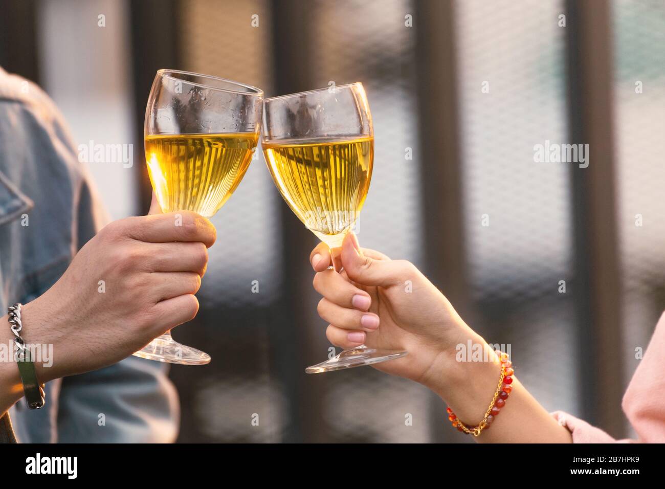 gros plan sur les mains des amoureux couple homme et femme applaudisse et toast avec des verres à vin blanc à célébrer lors d'un dîner-fête en été. amour, ce Banque D'Images