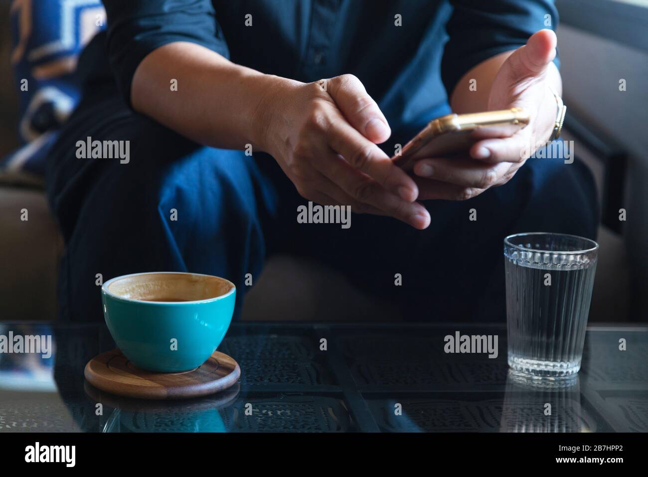 Businessman using smartphone pour lire les nouvelles en matière de placement et de réponse e-mail pour confirmer réunion à café. man drinking latte avant de se rendre au travail Banque D'Images