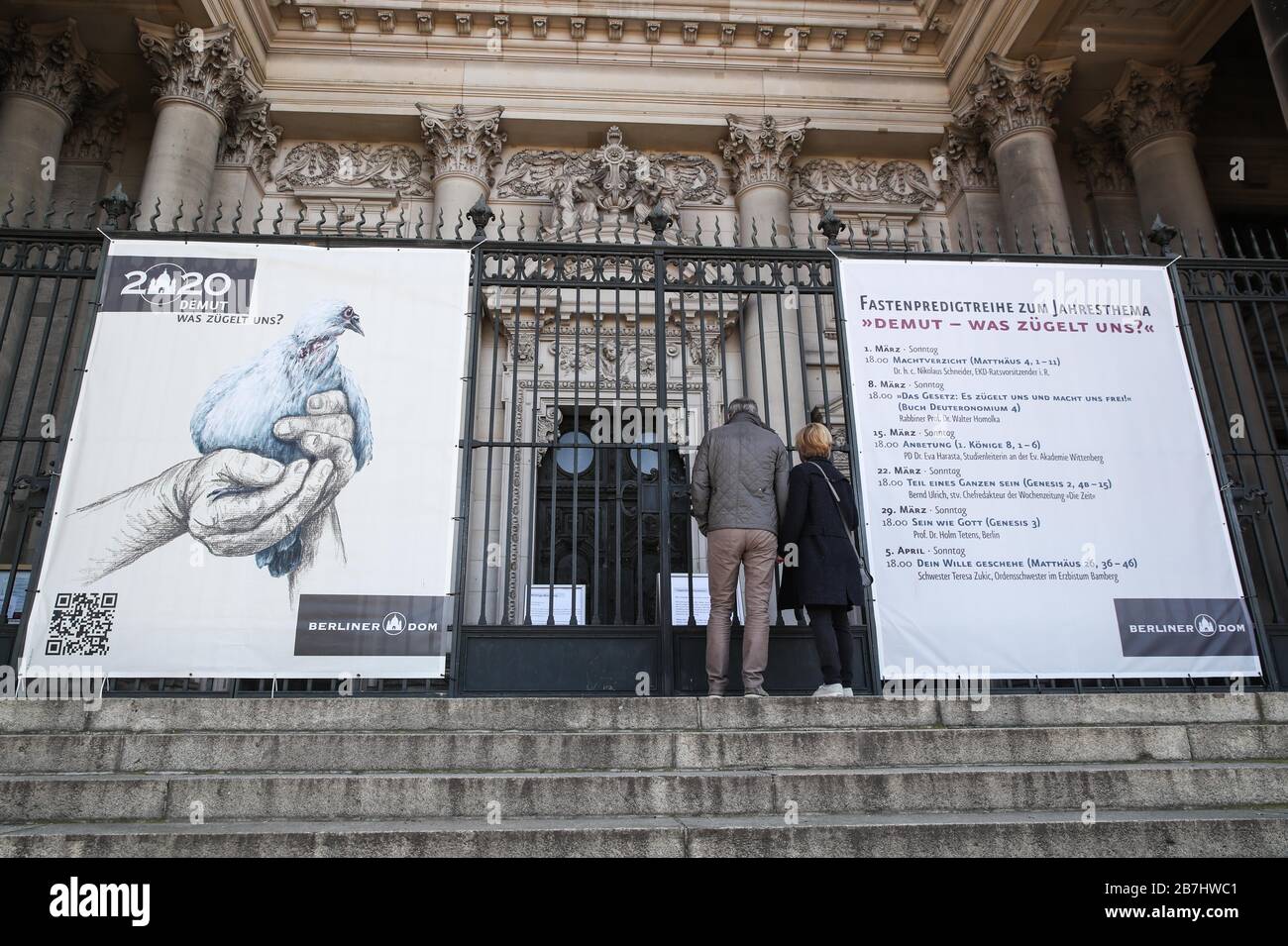 Berlin, Allemagne. 16 mars 2020. Deux piétons ont lu l'avis de clôture de la cathédrale de Berlin à Berlin, capitale de l'Allemagne, le 16 mars 2020. Les données de l'agence allemande de lutte contre la maladie ont montré que le nombre de cas confirmés de COVID-19 dans le pays a grimpé à 4 838 dimanche après-midi, soit 1 043 de plus que la veille. Le nombre de morts est passé à 12. Crédit: Shan Yuqi/Xinhua/Alay Live News Banque D'Images